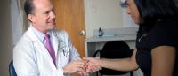 A doctor examines a patient's hand.